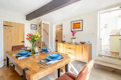 a dining room with a wooden table and chairs at 5 Mill Cottage in Yoxford