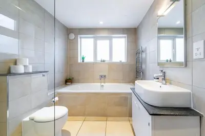 a bathroom with a tub and a sink and a toilet at 5 Mill Cottage in Yoxford