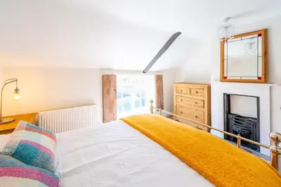 a bedroom with a bed and a fireplace at 5 Mill Cottage in Yoxford