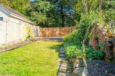 a backyard with a fence and a grass yard at 5 Mill Cottage in Yoxford