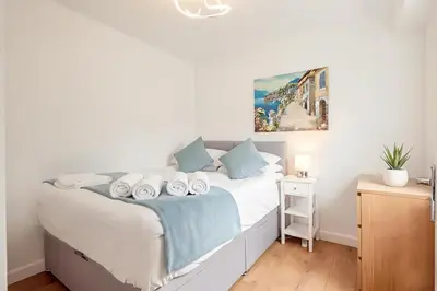 a bedroom with a white bed with blue pillows at Luxury City House - 1 min from river - Parking - Sleeps 10 in Cambridge