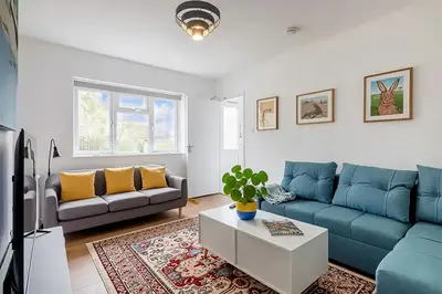a living room with a blue couch and a table at Luxury City House - 1 min from river - Parking - Sleeps 10 in Cambridge