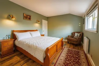 a bedroom with a bed and a chair and a window at Black Horse in Brent Pelham