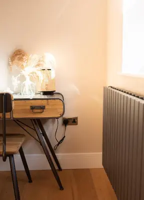 a table with a basket on it next to a radiator at Vineyard Style 2BR with Garden and Parking in Shudy Camps