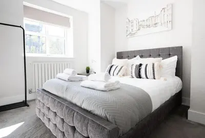 a bedroom with a large bed with white sheets and pillows at Vineyard Style 2BR with Garden and Parking in Shudy Camps