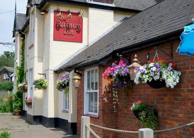 a building with flowers on the side of it at The Railway Inn Westerfield in Ipswich