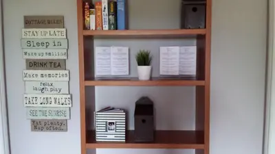 a book shelf with books and a speaker on it at The Railway Inn Westerfield in Ipswich