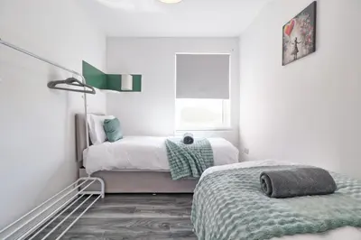 a white bedroom with two beds and a window at Comfy 4 Bed, Sleeps 8, fast WIFI, Contractor friendly in Hythe