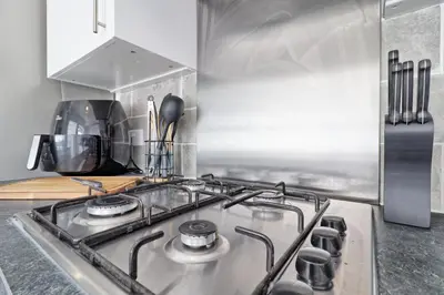 a kitchen with a stove and a refrigerator at Comfy 4 Bed, Sleeps 8, fast WIFI, Contractor friendly in Hythe