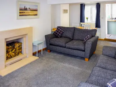 a living room with a couch and a fireplace at Cosy Cottage in Manningtree