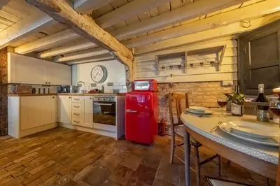 a kitchen with a red refrigerator and a table at The Dairy at Green Valley Farm in Laxfield