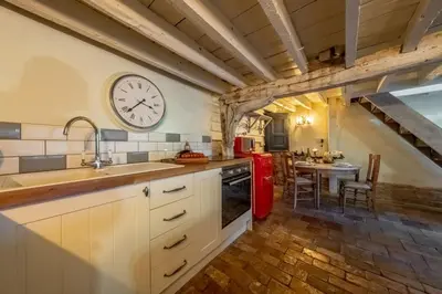 a kitchen with a red refrigerator and a table at The Dairy at Green Valley Farm in Laxfield