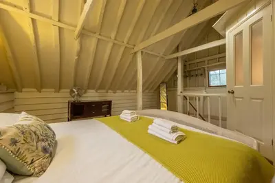 a bedroom with a bed in a attic at The Dairy at Green Valley Farm in Laxfield