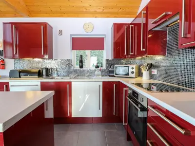 a kitchen with red cabinets and a counter top at Rookyard Cottage in Halesworth