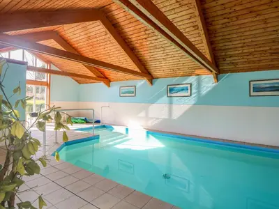 a swimming pool in a house with a wooden ceiling at Rookyard Cottage in Halesworth