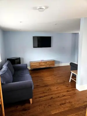 a living room with a couch and a flat screen tv at Little George in Rayne