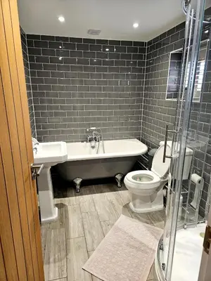 a bathroom with a tub and a toilet and a sink at Little George in Rayne