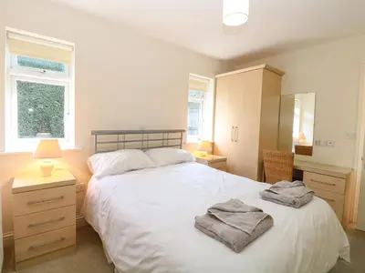 a bedroom with a large white bed with towels on it at Swallow Barn in Halesworth