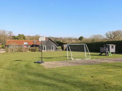 a soccer field with a net in the grass at Swallow Barn in Halesworth