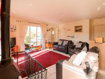 a living room with a couch and a television at Swallow Barn in Halesworth