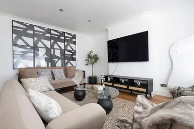 a living room with a couch and a flat screen tv at The Romford Oasis - Spacious 4 bedroom escape in Havering atte Bower