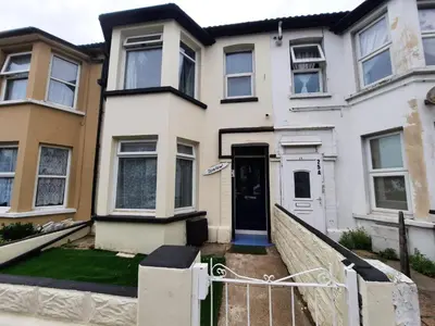 a white house with a gate in front of it at Seafront 2-Bed Apt Sleeps 4 in Clacton-on-Sea in Clacton-on-Sea