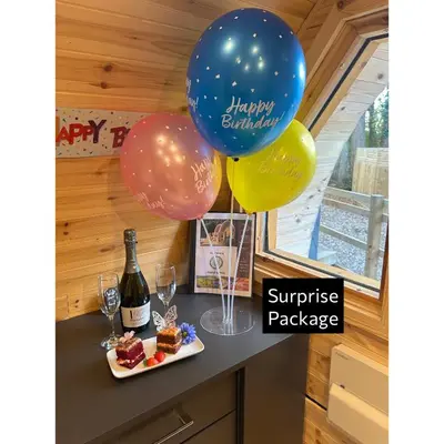 a bunch of balloons and a bottle of champagne and some desserts at Forrester Park Glamping Pods - Eagle Pod and Birdie Pods in Great Totham