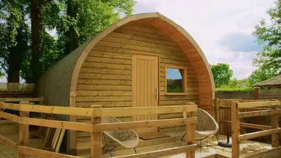 a wooden igloo house with a bench in a yard at Forrester Park Glamping Pods - Eagle Pod and Birdie Pods in Great Totham