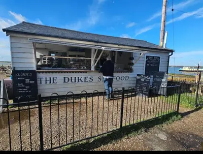 a man is standing outside of a food truck at The Beach House East Mersea in Mersea Island