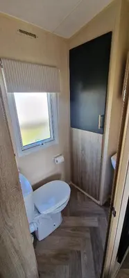a bathroom with a toilet and a window at The Beach House East Mersea in Mersea Island
