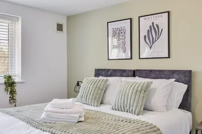 a bedroom with a white bed with two pillows at Cozy Riverside Cottage in Hertford Town with Parking in Hertford