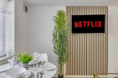 a dining room with a netflix sign on a wall at Cozy Riverside Cottage in Hertford Town with Parking in Hertford