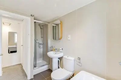 a bathroom with a toilet and a shower and a sink at Cozy Riverside Cottage in Hertford Town with Parking in Hertford