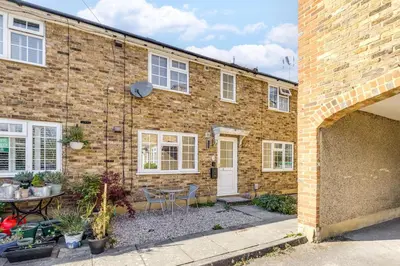 a brick house with a table and chairs in front of it at Cozy Riverside Cottage in Hertford Town with Parking in Hertford