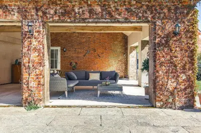 a brick wall with a couch and a table at Charming Rural Coach House Retreat - Wymondham in Wymondham