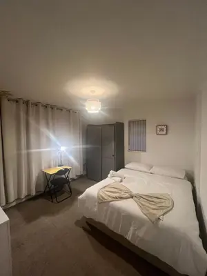 a bedroom with a large white bed and a table at Golden House in Waterbeach