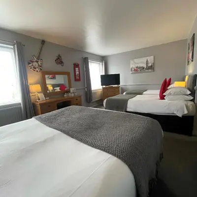 a hotel room with two beds and a mirror at The White Hart Hotel Witham in Witham