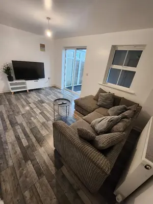 a living room with a couch and a flat screen tv at Cosy En-suite Rooms - Ipswich in Ipswich
