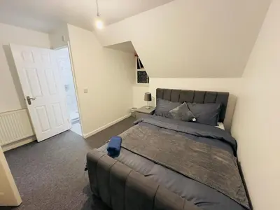 a bedroom with a large bed in a room at Cosy En-suite Rooms - Ipswich in Ipswich