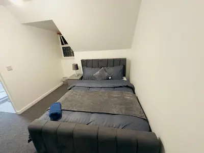 a bedroom with a large bed in a white wall at Cosy En-suite Rooms - Ipswich in Ipswich