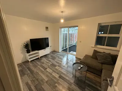 a living room with a couch and a flat screen tv at Cosy En-suite Rooms - Ipswich in Ipswich