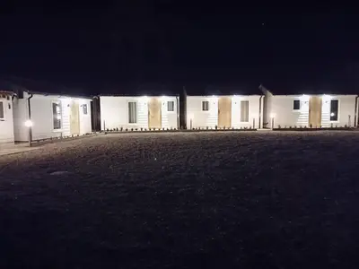 a row of white buildings at night with lights at The Beehive Inn in Bury Saint Edmunds