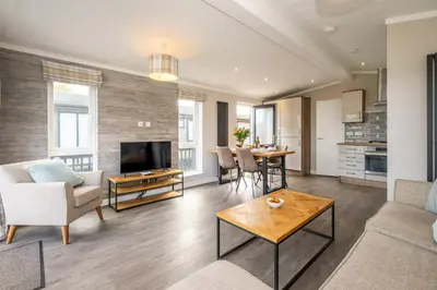a living room with a couch and a table at Driftwood Lodge, Sizewell - Adults only property - Aldeburgh Coastal Cottages in Sizewell