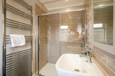 a bathroom with a sink and a glass shower at Driftwood Lodge, Sizewell - Adults only property - Aldeburgh Coastal Cottages in Sizewell