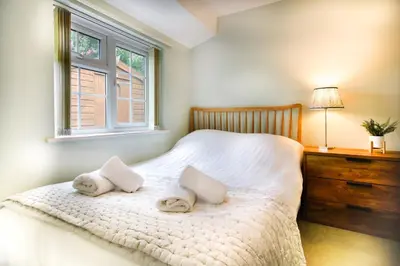 a bedroom with a bed with two towels on it at Cosy Home Opposite Addenbrookes Hospital - Free Parking in Cambridge