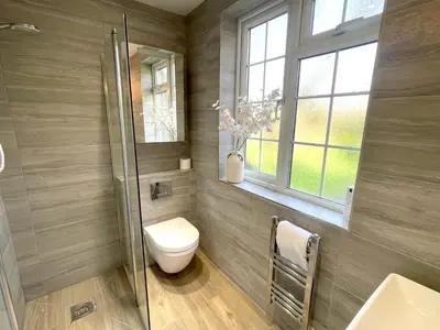 a bathroom with a toilet and a shower and a window at Cosy Home Opposite Addenbrookes Hospital - Free Parking in Cambridge