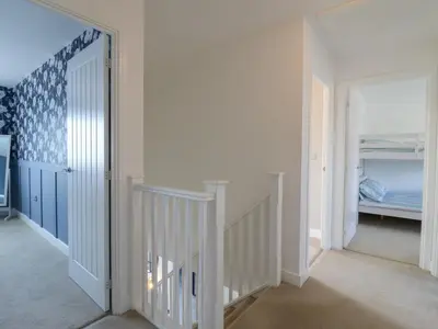 a hallway with a staircase leading to a bedroom at 21 Skippers Way in Walton-on-the-Naze