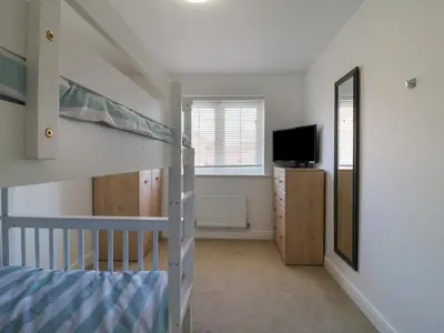 a bedroom with a bunk bed and a tv at 21 Skippers Way in Walton-on-the-Naze