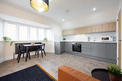 a living room with a table and a kitchen at 8 The Royal Serviced Apartments ,Harwich, One Bed Parking, Fast Wifi, Space Apartments in Parkeston