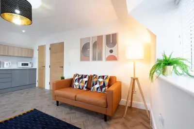 a living room with a couch and a kitchen at 8 The Royal Serviced Apartments ,Harwich, One Bed Parking, Fast Wifi, Space Apartments in Parkeston